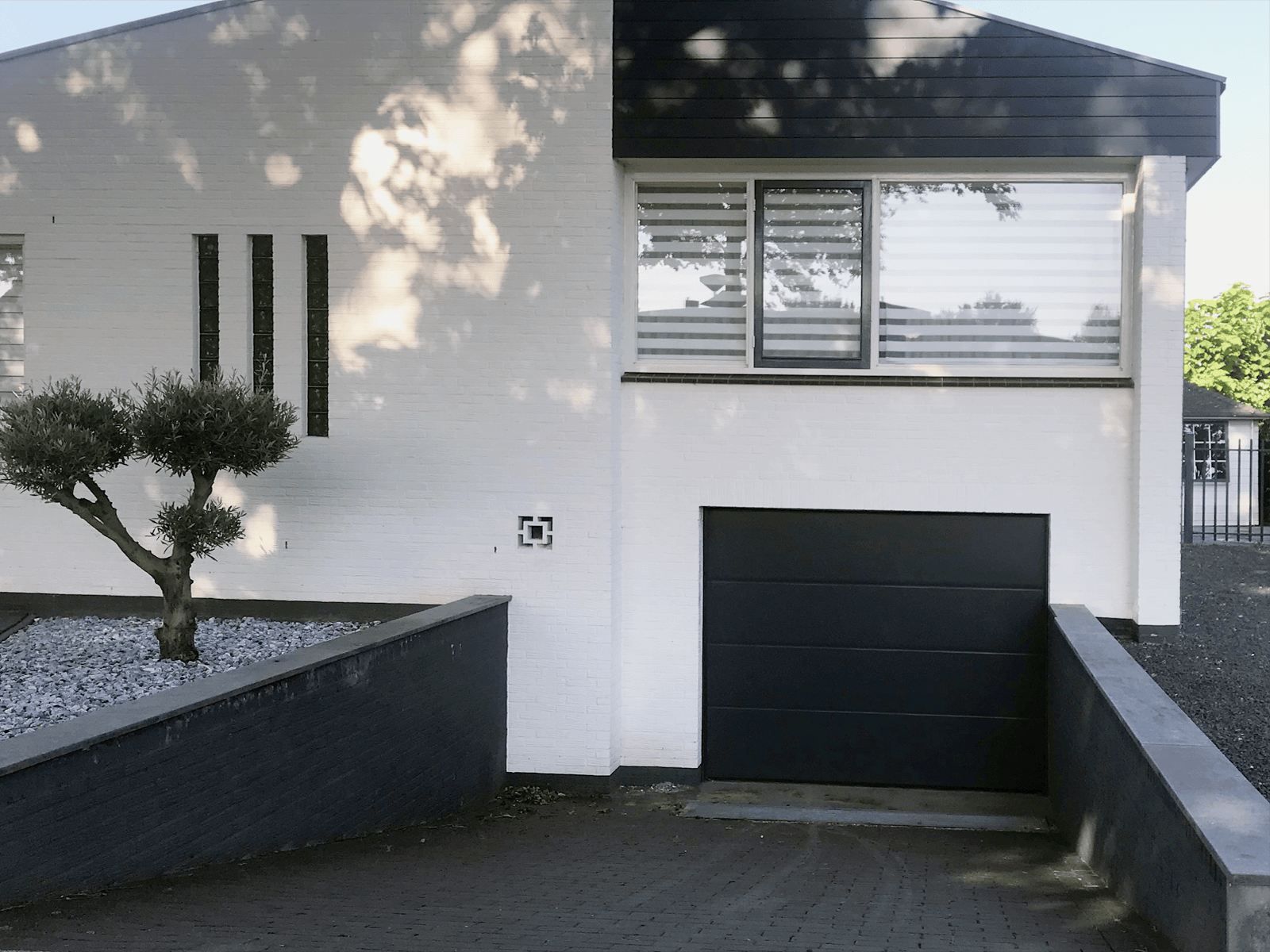 Zwarte sectionale garagedeur in moderne gevel 06 RA 9005 - Zwarte sectionale garagedeur in moderne gevel